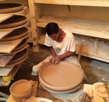 Man making ceramic bowl on pottery wheel