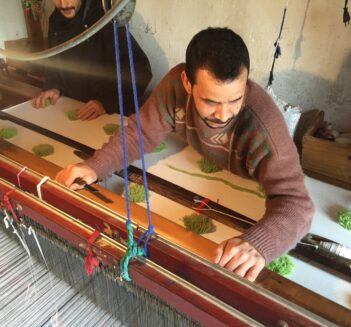 man weaving on big loom