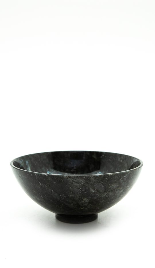 black bowl of labradorite on a white background