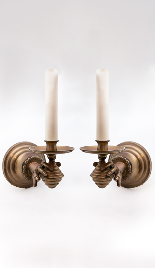 PAir of hands holding candles wall sconces