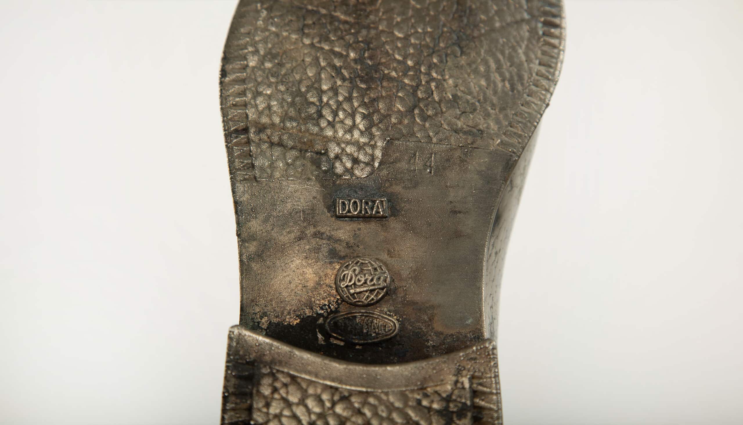 Sculpted Sole: Novelty Metal Boot with Industrial Markings
